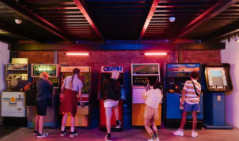 Line of old-school arcade machines in a traditional arcade setting.